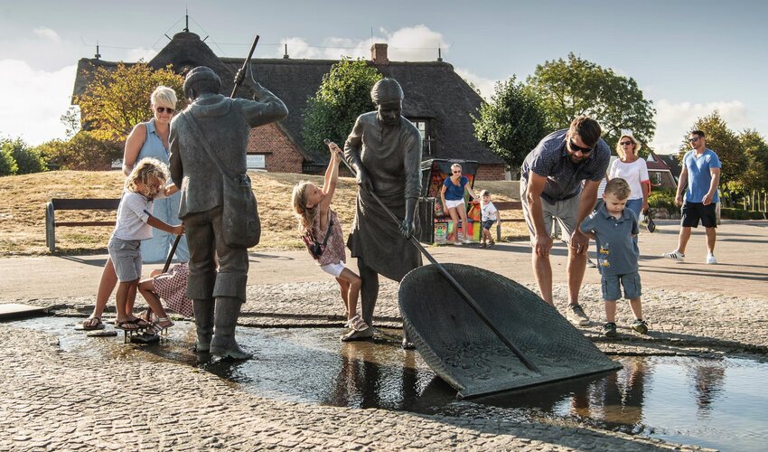 Familie bei den Figuren von Jan und Gret beim Marktplatz