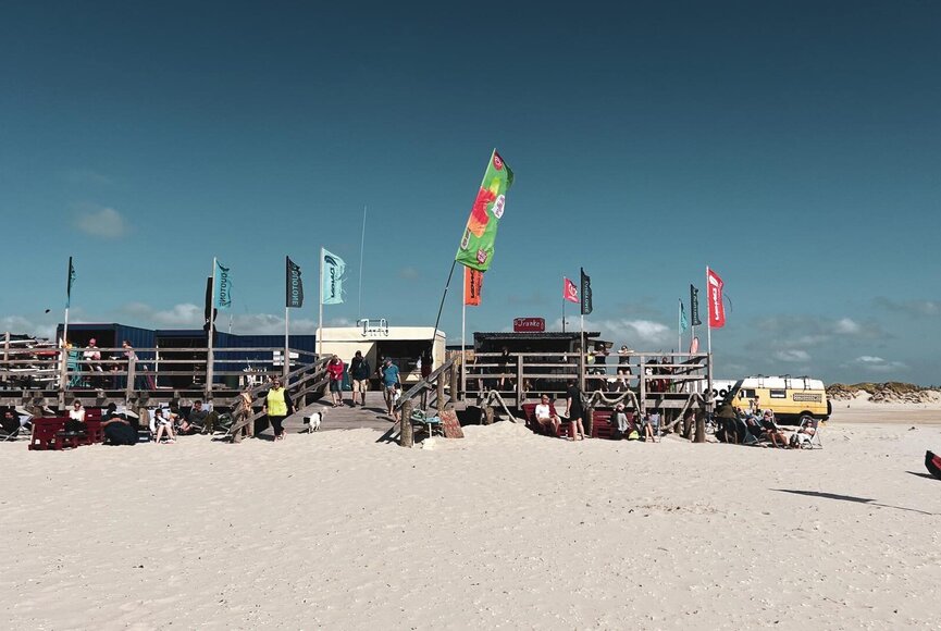 Surf school on the beach with containers on a platform built on stilts