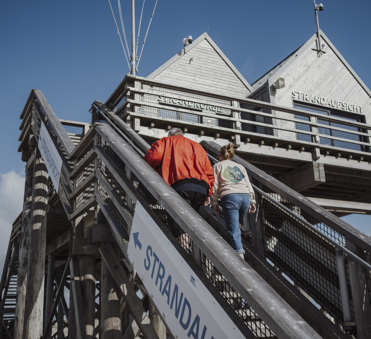 Simone und Heinzi gehen die Treppe zum Pfahlbau hoch 