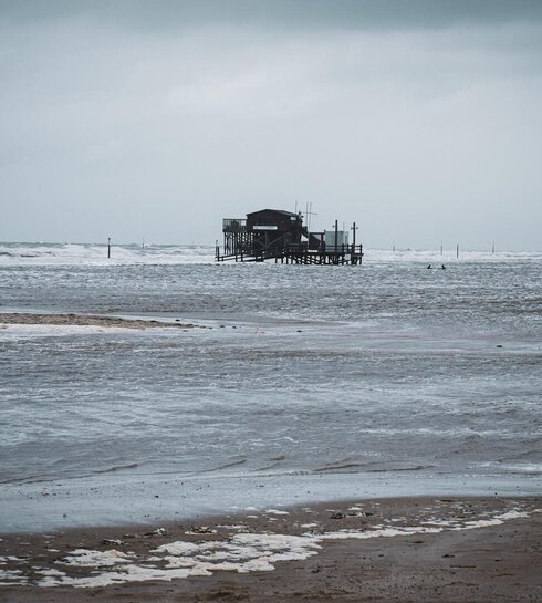 Pfahlbau umgeben von Wasser während einer Sturmflut 