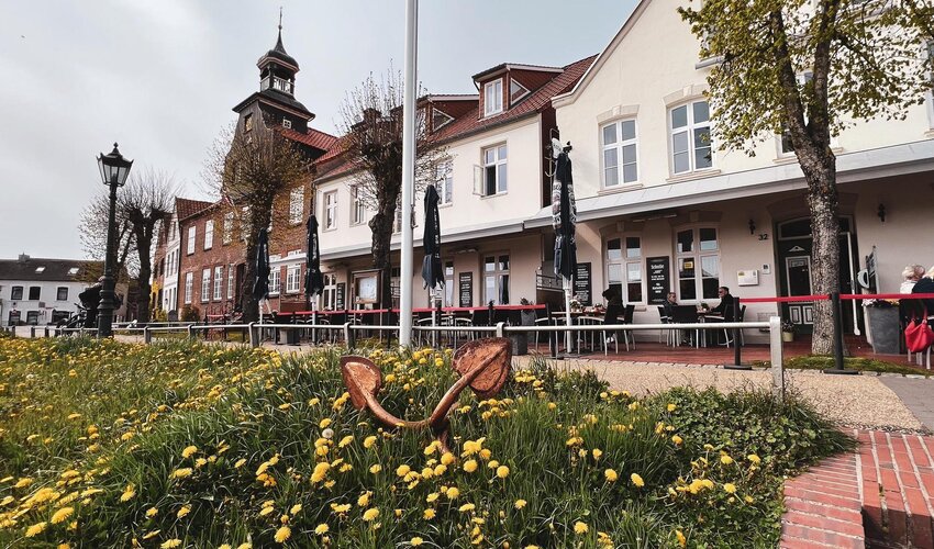 Häuserreihe am Tönninger Hafen mit Kirchturm im Hintergrund