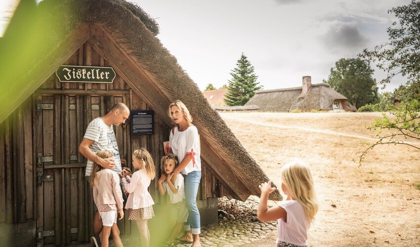 Familie vor dem Nachbau eines Eiskellers